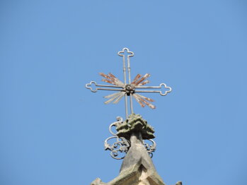 Růžice s křížem na vrcholu hlavního průčelí